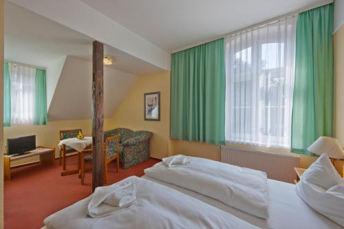 a hotel room with two beds and a living room at Hotel Deutscher Hof in Bad Wilsnack