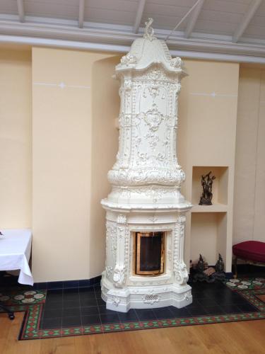 a large white fireplace in a room with a table at Hotel Deutscher Hof in Bad Wilsnack