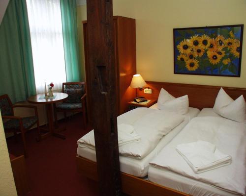 a hotel room with a bed and a table at Hotel Deutscher Hof in Bad Wilsnack