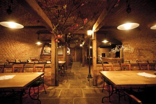 a restaurant with tables and chairs and a brick wall at Hotel Gold Chotoviny in Chotoviny