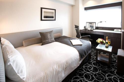 a hotel room with a bed and a desk at Hotel Bellclassic Tokyo in Tokyo