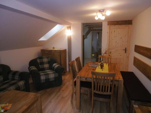 ein Wohnzimmer mit einem Tisch, Stühlen und einem Sofa in der Unterkunft Ferienhof Hering in Hinterhermsdorf