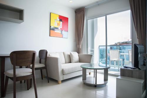a living room with a couch and a table at Grandblue Condominium 708 in Ban Nam Lai Ta Tum