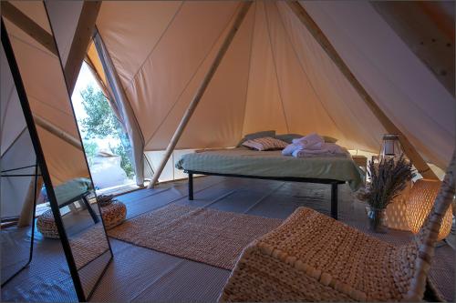 PristanišćeにあるGlamping resort Fešta Kornatiのテント内のベッド1台が備わるベッドルーム1室
