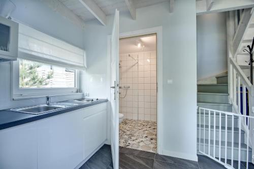 een badkamer met een wastafel en een douche bij Skandynawskie Domy in Pobierowo