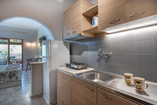 a kitchen with a sink and a refrigerator at Maria Studios in Keri