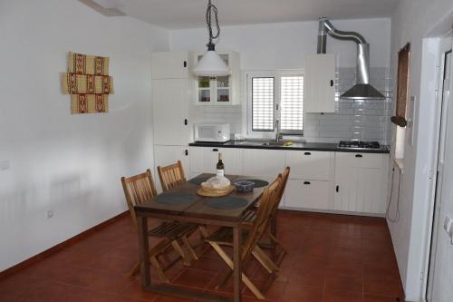 a kitchen with a table and chairs in a room at Monte Quinta Verde in Ferreira do Alentejo