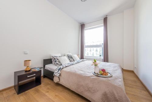 Un dormitorio con una cama con una bandeja de fruta. en Wola Park - Obozowa 16 P&O Apartments, en Varsovia