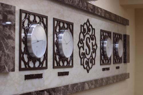 a row of clocks on a wall in a room at SAFIR BUSINESS HOTEL o in Dushanbe