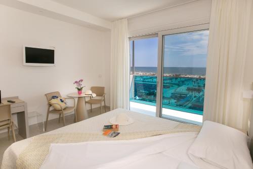 a bedroom with a bed and a view of a pool at Hotel Pineta in Sottomarina