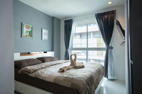 ein Schlafzimmer mit einem Bett mit einem ausgestopften Tier darauf in der Unterkunft Grandblue Condo by malai in Mae Pim