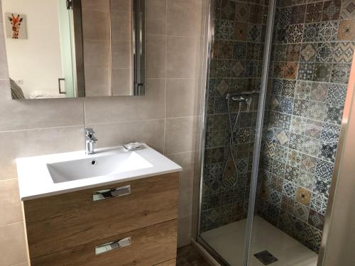 W łazience znajduje się umywalka i prysznic. w obiekcie Albergue-Pensión Cabo da Vila w mieście Fisterra