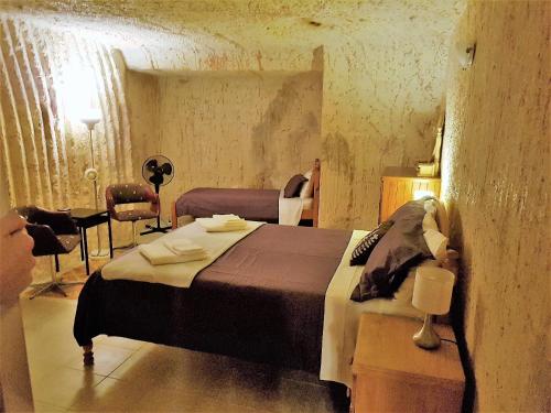 Schlafzimmer mit einem Bett, einem Tisch und Stühlen in der Unterkunft Underground Gem in Coober Pedy