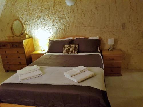 a bedroom with a bed with two towels on it at Underground Gem in Coober Pedy