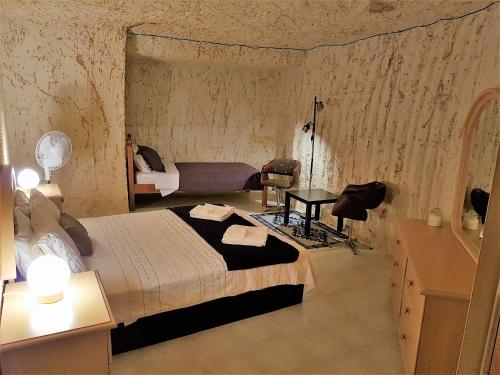 a bedroom with a bed and a table in a room at Underground Gem in Coober Pedy