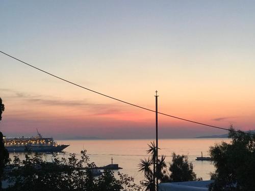 a cruise ship in the water at sunset at Studios & Suites Rania in Mikonos