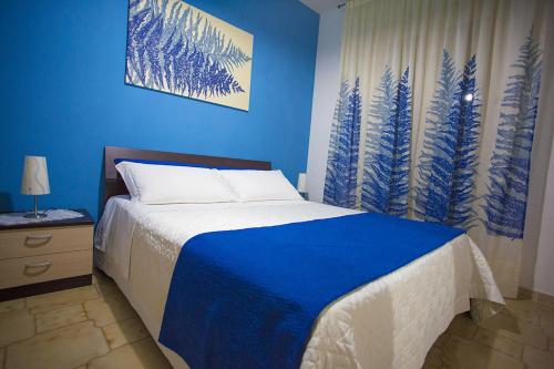 Dormitorio azul con cama y pared azul en B&B Terra Nobile - Portopalo, en Portopalo di Capo Passero