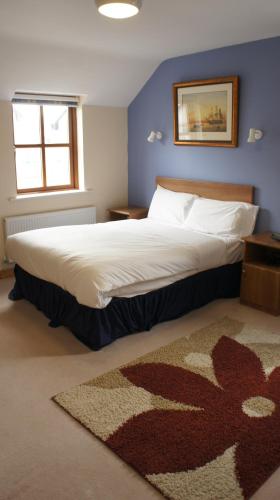 a bedroom with a large bed with a rug at Dalys Inn in Donore