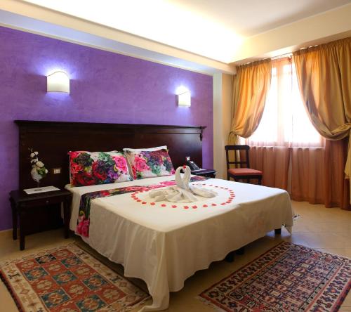 ペトロジーノにあるSammartano Hotelsの紫の壁のベッドルーム1室(大型ベッド1台付)