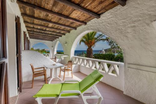 a balcony with a table and chairs and the ocean at Hotel Mon Repos in Baja Sardinia