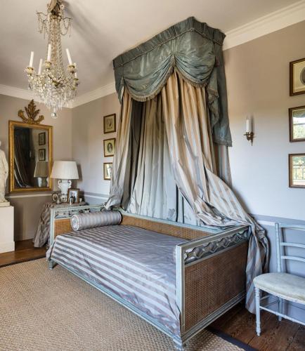 - une chambre avec un lit à baldaquin et un lustre dans l'établissement Villa-A, à Rouillac