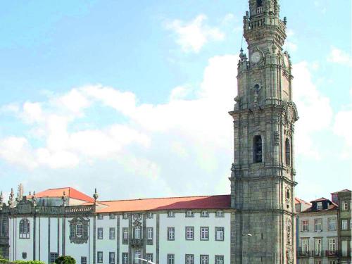 a building with a clock tower in front of a building at ibis Porto Centro São Bento in Porto