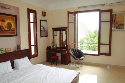 a bedroom with a bed and a desk and a window at Hạ Long Lily Homestay in Ha Long