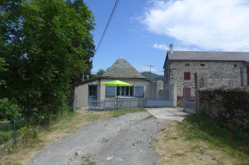 a house with a green roof on a dirt road at La P'tite Maison in Saint-Hostien