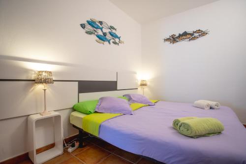 コティージョにあるCasa Checa Apartment 1のベッドルーム1室(紫のシーツと緑の枕が備わるベッド1台付)