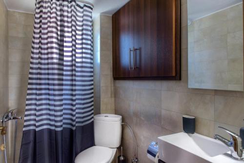 a small bathroom with a toilet and a sink at Pleiades Casual Living in Nea Roda
