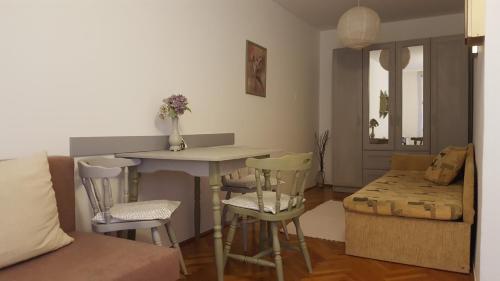 セゲドにあるHortenzia Apartmentのリビングルーム(テーブル、椅子、ソファ付)
