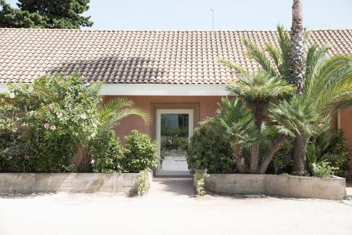 a house with palm trees in front of it at L'Albero in Porto Empedocle
