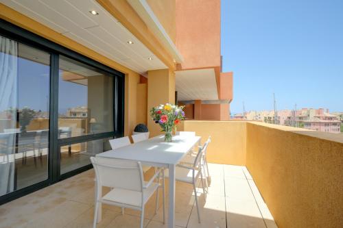 a white table and chairs on a balcony at Ribera del Marlin - Sotogrande in Sotogrande
