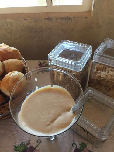 a bowl of food with bread and containers of food at Hotel Alto da Boa Vista in Analândia