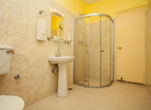 un bagno con doccia, lavandino e WC di Hotel Crown Himalayas a Pokhara