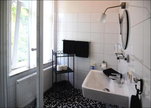 a bathroom with a sink and a mirror and a window at Hotel Herberge zur Traube in Bad Wimpfen