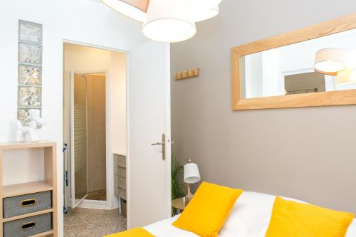 une chambre avec un lit et un miroir dans l'établissement Cannes Le Vendome, à Cannes