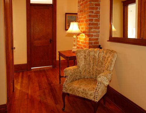 a room with a chair and a table with a lamp at Au Virage B&B in Magog-Orford