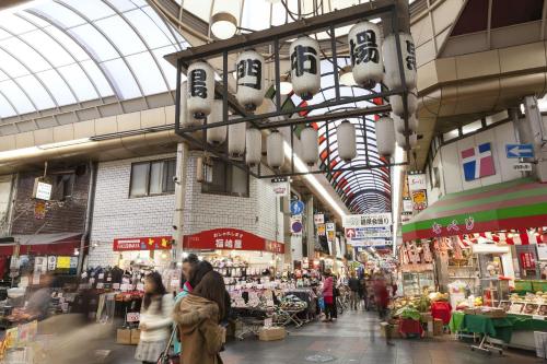 a market with people walking around in a building at Osaka Tokyu REI Hotel in Osaka
