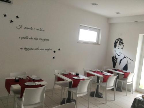 マルティンシクーロにあるB&B FARAONEの壁に看板のあるテーブルと椅子が備わるレストラン