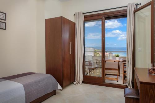 a bedroom with a bed and a window with a view at Pleiades Casual Living in Nea Roda