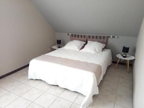 um quarto com uma cama branca e duas mesas em "Kaz Misèl"65 m carré 4 nuits minimum em Saint-Paul