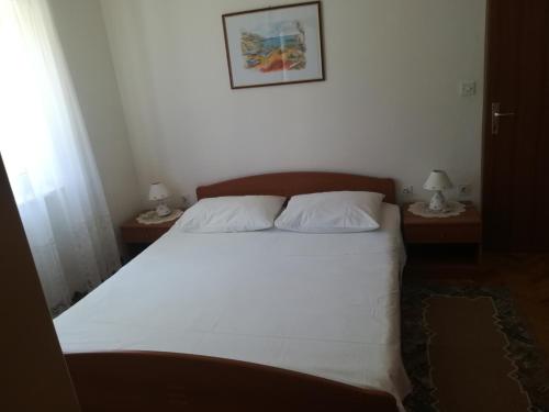 1 dormitorio con 1 cama grande y 2 mesitas de noche en Apartments Jelić, en Banići