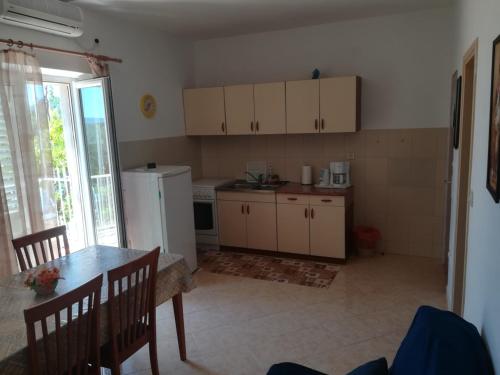 a kitchen with a table and a refrigerator at Apartments Jelić in Banići