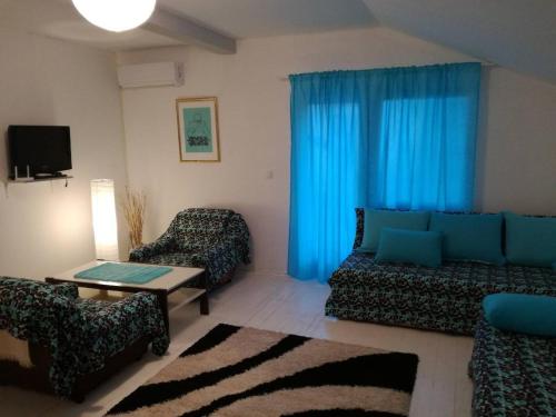 sala de estar con cortinas azules y sofá en Cherry flower ( Trešnjin Cvet ) apartment, en Višegrad