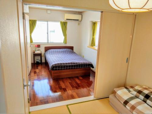 a bedroom with a bed and a sliding glass door at Duplex Makishi in Makishimachi