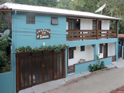 a blue and white house with a gate at Pousada Quatro Estacoes in Trindade