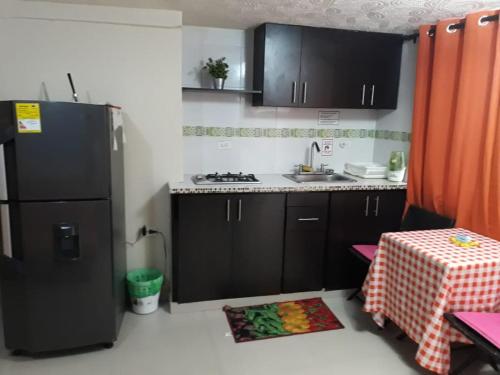 a small kitchen with a black refrigerator and a table at Posada J&J Forbes - 2 in San Andrés