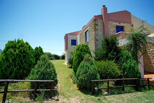 a house with two benches in front of it at Villa Myrto in Kyparissia