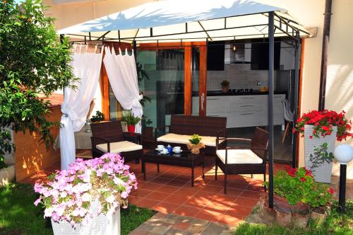 Un patio con una mesa y sillas bajo una sombrilla. en Brezza di Mare, en San Teodoro
